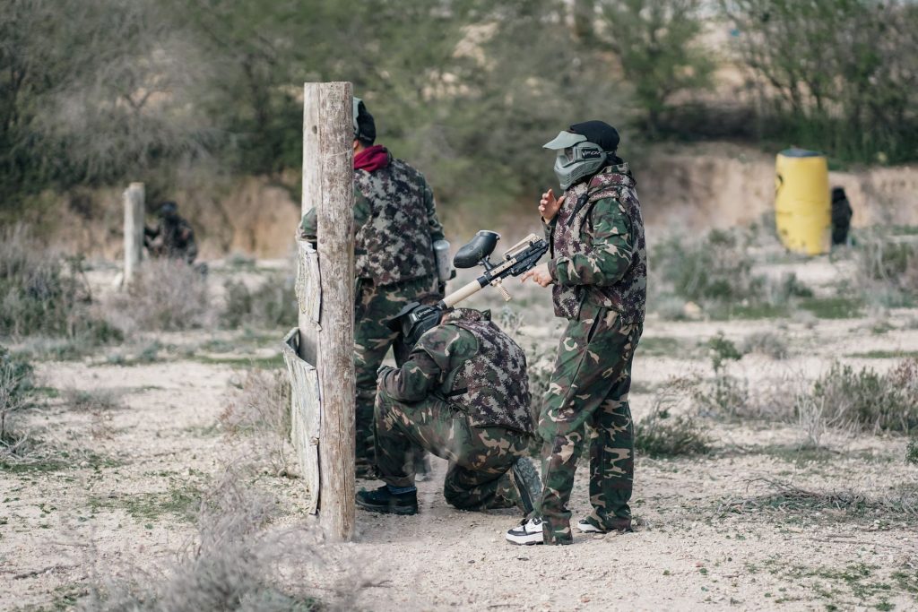 Groupe d'adultes en tenue camouflage pendant une partie de paintball